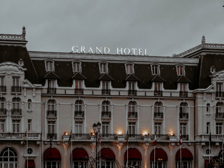 A stunning view of the Grand Hotel's illuminated facade in overcast weather.