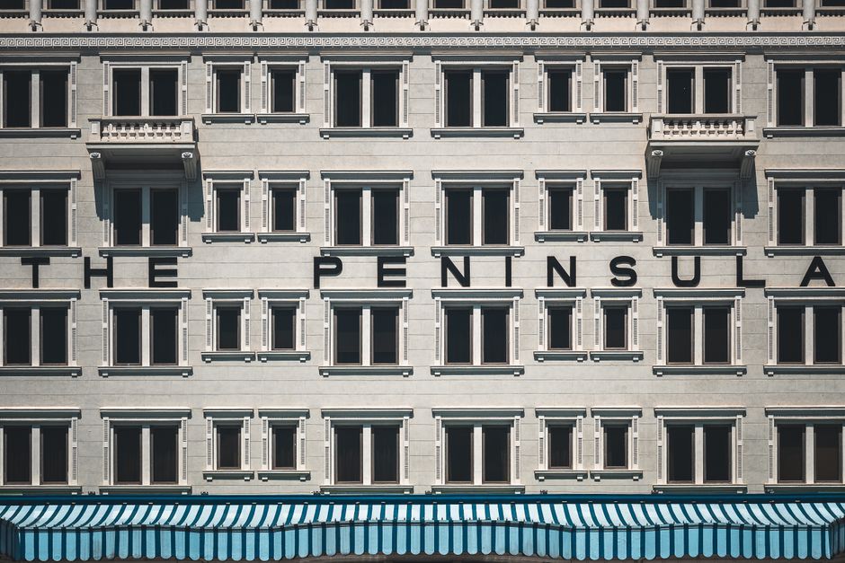Close-up of The Peninsula Hotel facade in Hong Kong showcasing its unique architectural design.