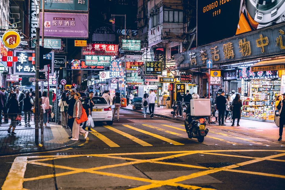Explore the lively night life in Hong Kong's bustling streets, filled with bright neon signs and busy pedestrians.